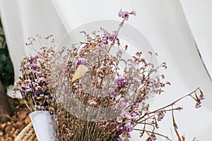 Violet Dried Caspia and Dried Statice flowers bouquet in Vintage Style. Garden blur background. Purple and brown flowers