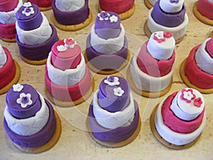 Violet and grenadine cupcakes in form of the mini wedding cakes