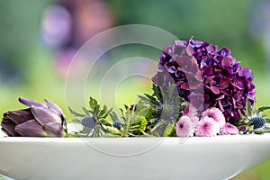 Violet hydrangea, artichoke and pink daisies in beautiful flower arrangement