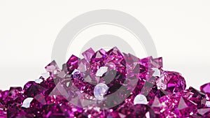 Violet jewel stones heap turning over white, loop ready
