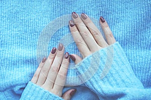 Violet manicure and blue sweater.
