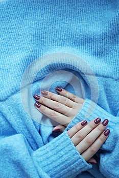 Violet manicure and blue sweater.