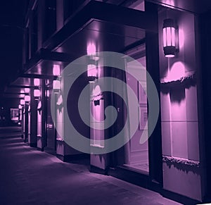 Violet night lighting of modern city building facade