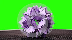 Violet origami flower on green screen.