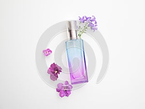 Violet perfume bottle with flowers around. lavender and spring flower aroma, aromatherapy, spa concept, skin care