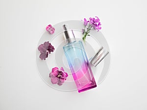 Violet perfume bottle with flowers around. lavender and spring flower aroma, aromatherapy, spa concept, skin care