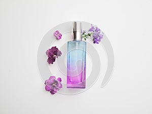 Violet perfume bottle with flowers around. lavender and spring flower aroma, aromatherapy, spa concept, skin care
