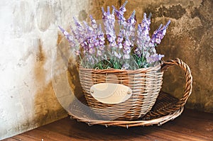 Violet plastic flowers in wooden pot