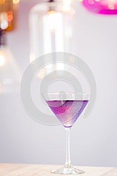 Violet or Purple Cocktail with Sequins, Margarita or Daiquiri Cocktail in Bar, Vertical View