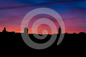 Violet sunset above moroccan city Fes with silhouette of minarets