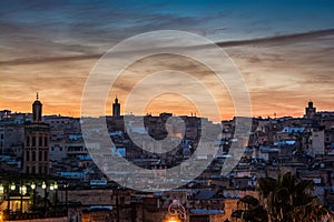 Violet sunset above moroccan city Fes with silhouette of minarets