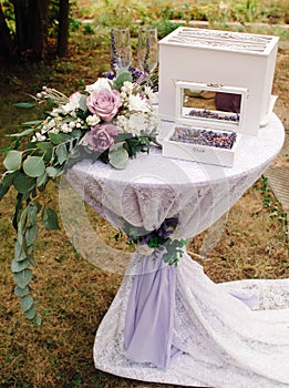 Violet wedding concept. Wedding rings with elegant purple floral decorations at the garden