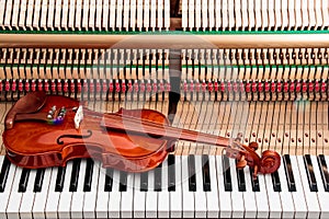 Violin on black and white piano keys with inside the piano background