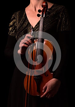 Violin and bow in the hands of the musician isolated on black