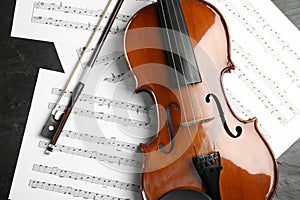 Violin, bow and note sheets on stone table