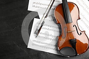 Violin, bow and note sheets on stone table