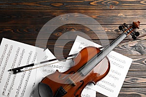 Violin, bow and note sheets on wooden table. Space for text