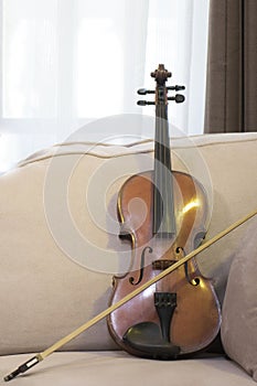 Violin and bow resting on the sofa
