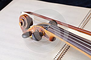 Violin bow and scroll on music book