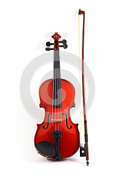 Violin with bow upright on whi photo