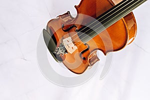 Violin without bow on a white marble background. Selective focus