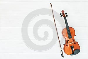 Violin and bow on white wood background.