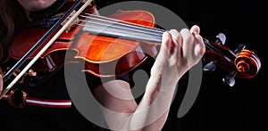 Violin classic musical instrument. Classic player hands on a black background. Details of violin playing