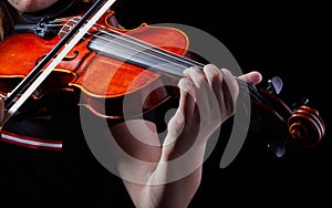 Violin classic musical instrument. Classic player hands on a black background. Details of violin playing