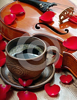 Violin and a cup of coffee. Coffee and rose petals. Top view. close up.