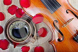 Violin and a cup of coffee. Coffee and rose petals. Top view. close up.