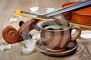 Violin and a cup of coffee. Coffee and rose petals.