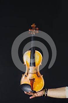 Violin in hand on a black background