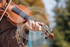 Violin in the hands of a musician during a concert on the street_