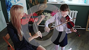 Violin lesson - a little girl and her teacher playing violin