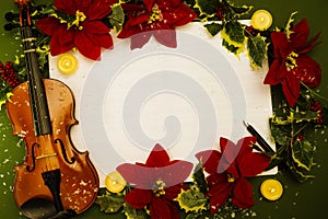 Violin and open music manuscript on the green background. Christmas concept