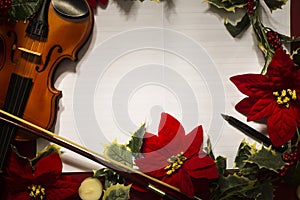 Violin and open music manuscript on the red background. Christmas concept