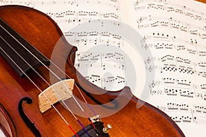 Violin over a music score sheet