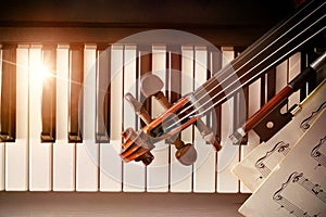 Violin pegbox bow and sheet music on piano keys top photo