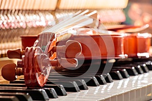 Violin on the piano keys with back sunshine light