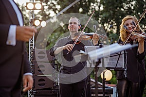 Violin players playing in orchestra on the street