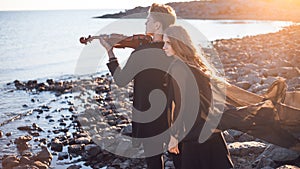 Violinist and girl, young man plays on the