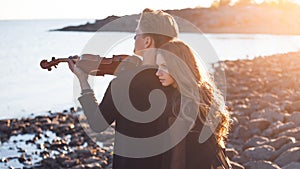 Violinist and girl, young man plays on the