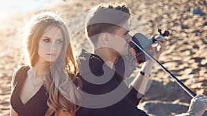 Violinist and girl, young man plays on the