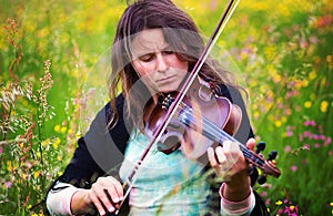 Violinist on a meadow full of flowers