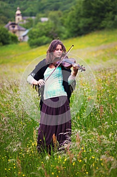 Violinist on a meadow full of flowers