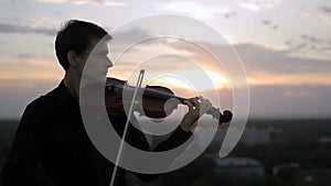 Violinist puts musical instrument on his shoulder and begins to play