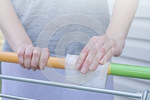 Viral disease prevention concept. Woman wipes down a handle of public shopping cart with a disinfecting moist towelette in mall or