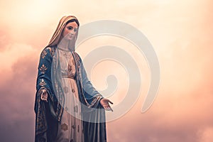 Virgin Mary statue at Catholic church with sunlight in cloudy day background.