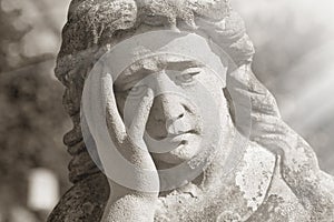 Virgin Mary statue. Vintage sculpture of sad woman in grief Rel