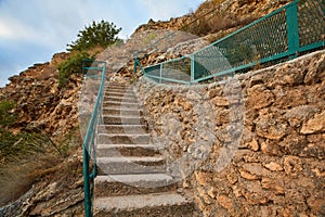 Virgin nature. Outdoor. Landscape. Stone staircase. Old long stairs with handrail. Rocky terrain. Stunning hidden place
